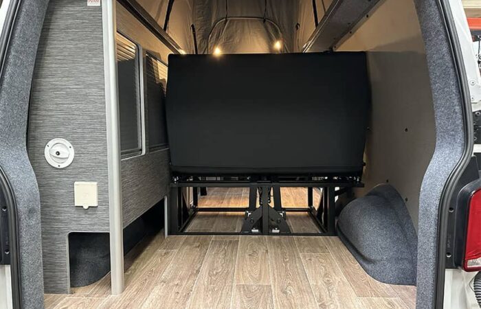 Vue arrière d'un van aménagé par Ovan avec banquette relevable et espace de rangement